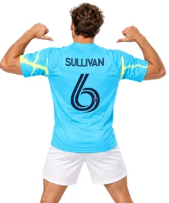 Model wearing Cavan Sullivan 2026 away soccer jersey in electric cyan with yellow lightning patterns