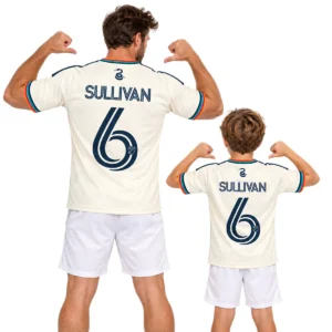 Father and son wearing matching cream Philadelphia Union Sullivan No. 6 jerseys with multicolor trim