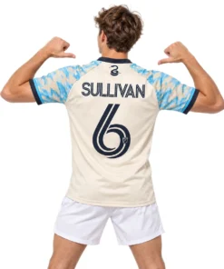 Young model wearing cream Philadelphia Union Cavan Sullivan jersey with blue camouflage graphics