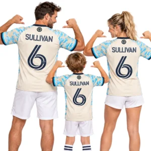 Family wearing matching cream and sky-blue Philadelphia Union Sullivan No. 6 jerseys