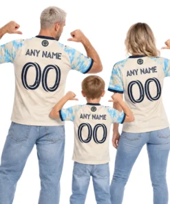 Father, mother and son wearing matching cream and sky-blue Philadelphia Union throwback soccer jerseys